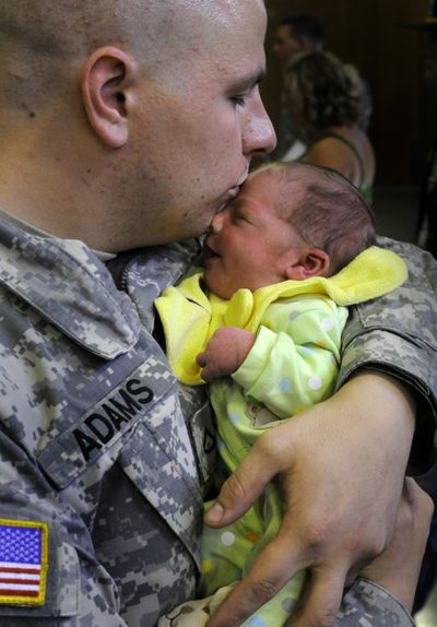 U.S. Army Reserve Pfc. Nicholas Adams, a member of the 643rd Automated Cargo Documentation Detachment, holds his newborn son, Connor, at a deployment ceremony Monday in Spokane. (Colin Mulvany / The Spokesman-Review)