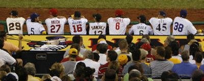 
National Leaguers perch on the top of the rail during Tuesday night's game in Pittsburgh. 
 (Associated Press / The Spokesman-Review)