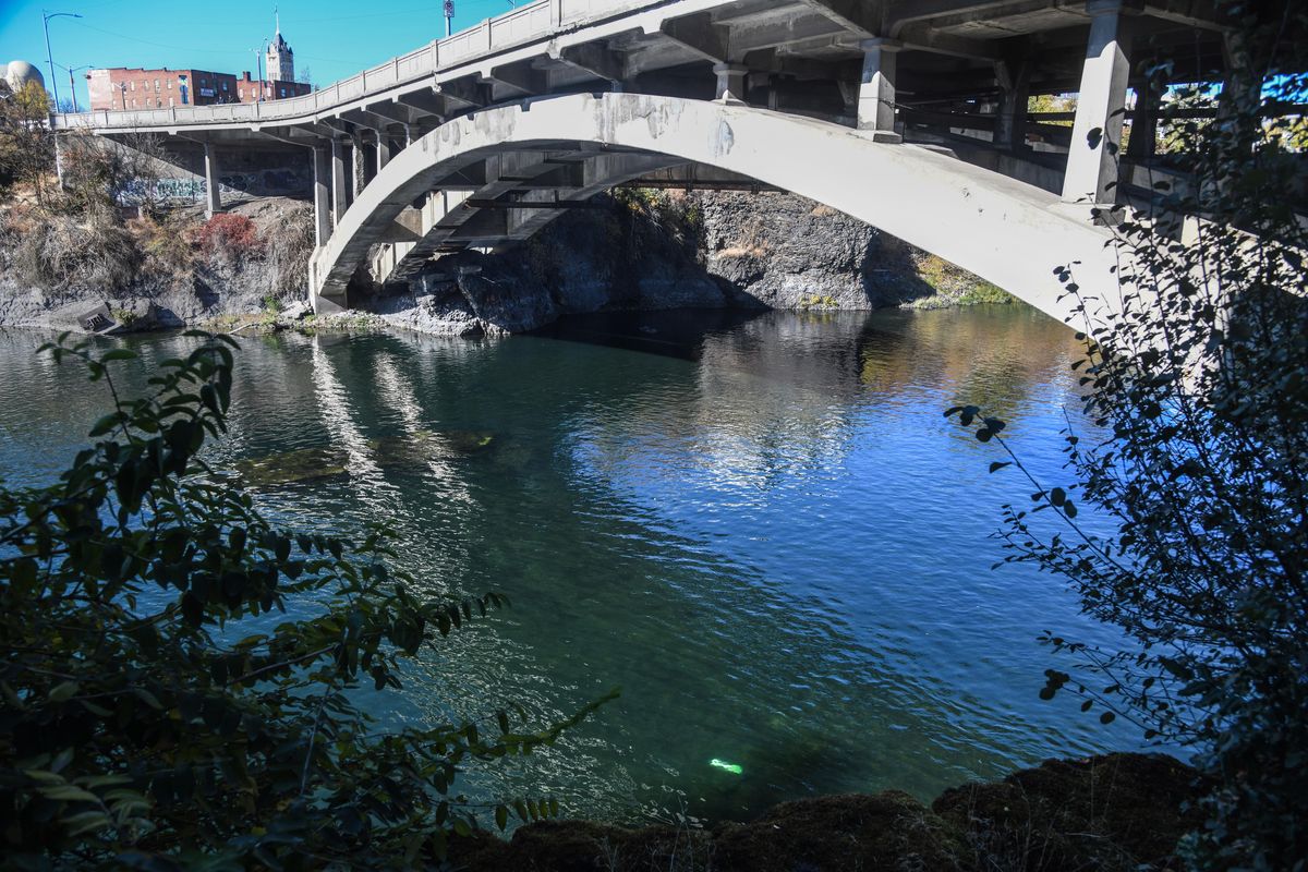 A Lime scooter (bottom, center) lies beneath the surface of the Spokane River under the Post Street Bridge. (Dan Pelle / The Spokesman-Review)