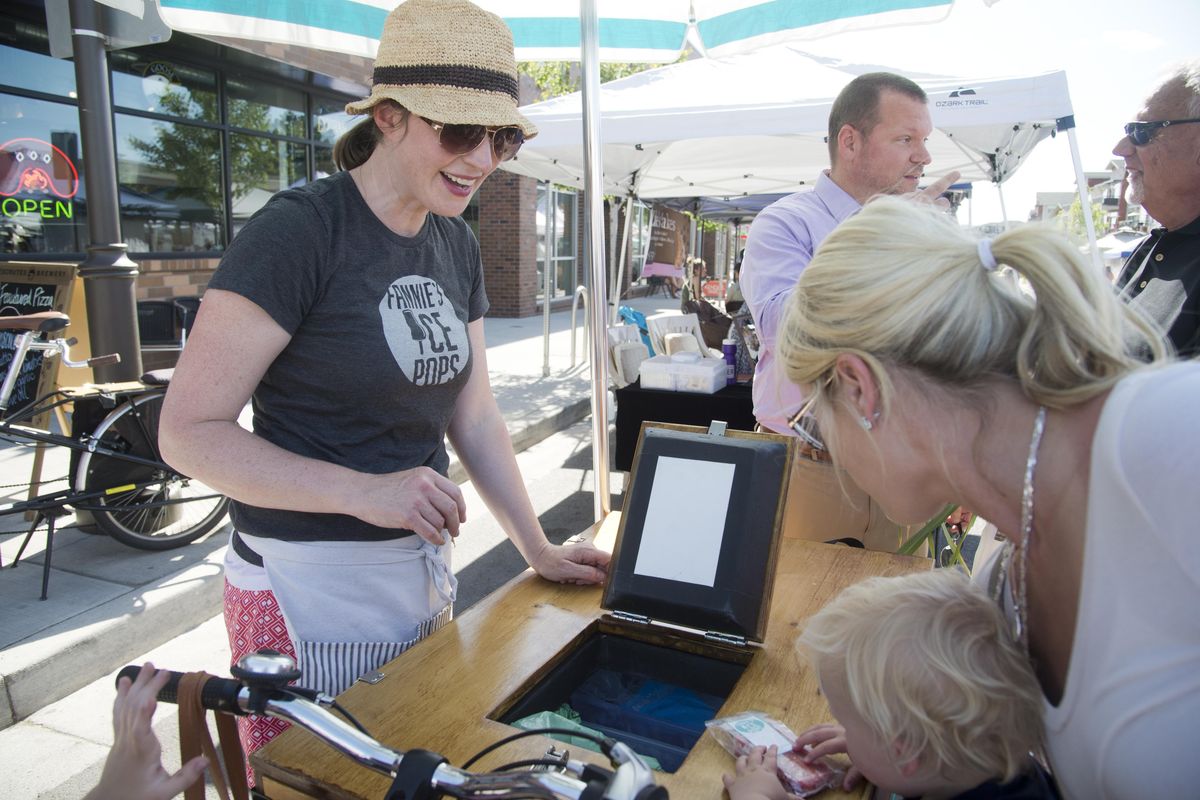 Mandolyn Hume, left, does a bang-up business Wednesday, June 10, 2015 at the Night Market at Kendall Yards. Hume makes and sells gourmet ice pops in flavors such as raspberry-basil, cucumber-apple and cold-brew coffee. (Jesse Tinsley / The Spokesman-Review)