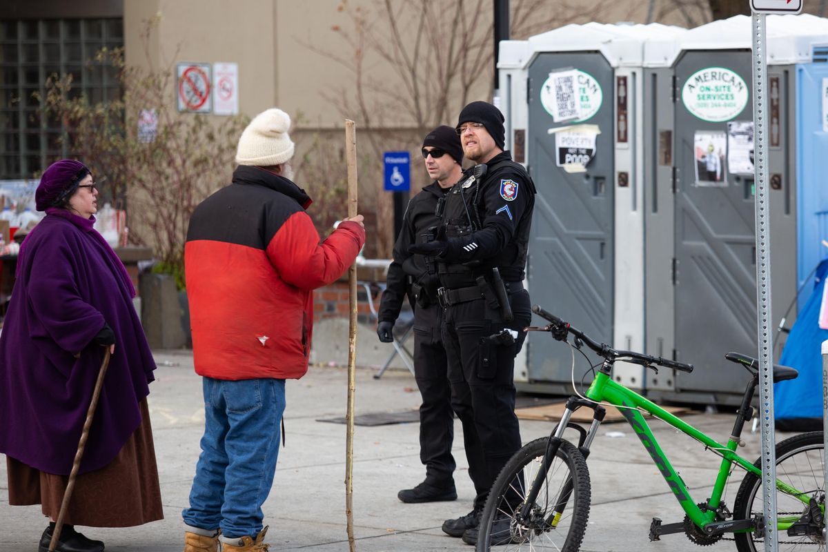 The Spokane Police Department clears out protesters and their belongings near a City Hall homeless encampment on Dec. 9, 2018. The 48-hour notice to remove property was posted on Thursday. (Libby Kamrowski / The Spokesman-Review)