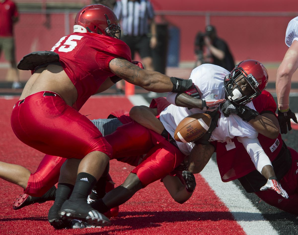 EWU defender John Goldwire, left, punches the ball away from running back Mario Brown but not before he crossed goal line. (Dan Pelle)
