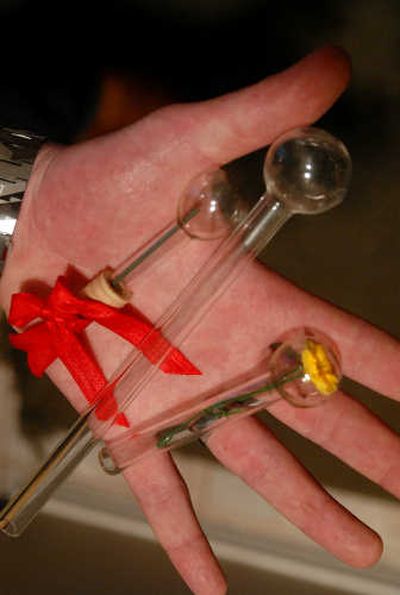 
Mike Conrad, of Spokane, displays a glass-encased fake rose and similar glass novelties that came without a flower inside. He purchased them from a mini-mart last week.  
 (Jesse Tinsley / The Spokesman-Review)