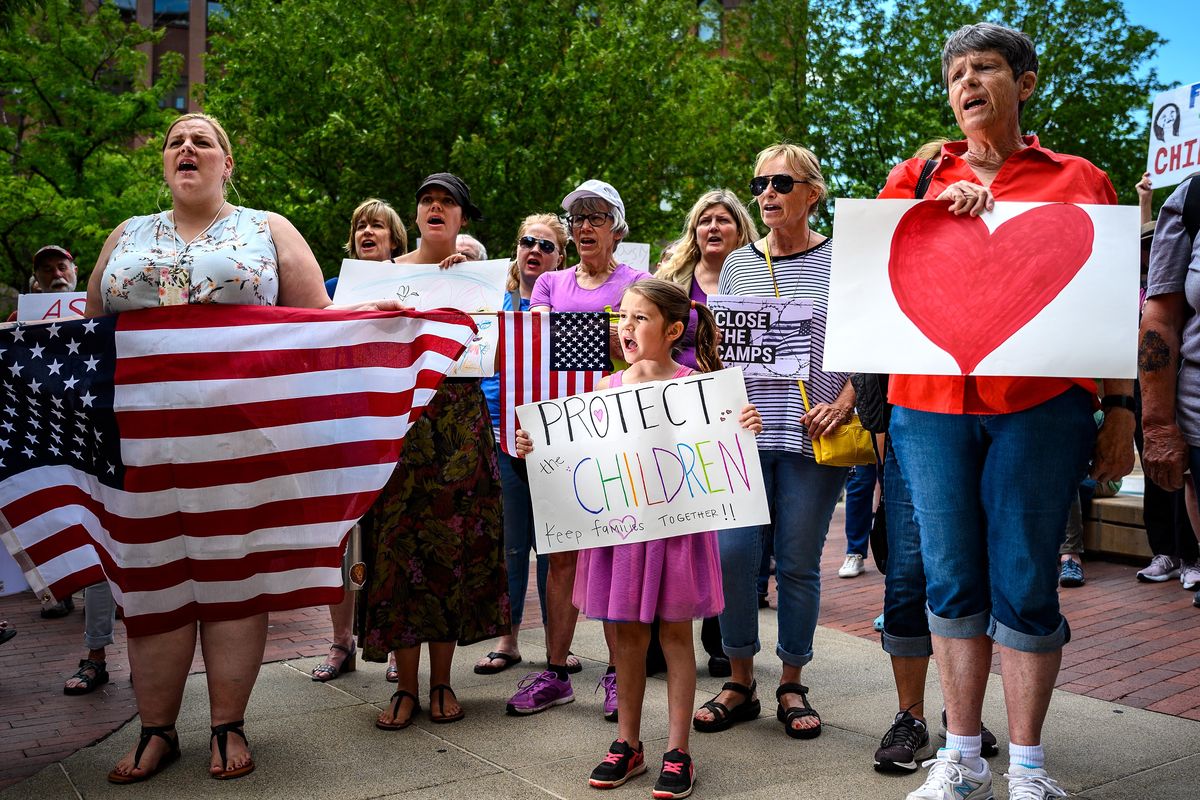 At the Thomas S. Foley United States Courthouse, left to right, Liz Marlin, Evalyn Brown, 6, and Sue Luppert, show their support Tuesday at the Close the Camps rally. (Colin Mulvany / The Spokesman-Review)