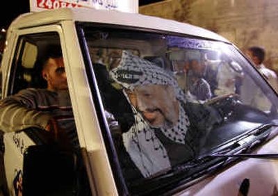 
Palestinians drive their car with a poster of Palestinian leader Yasser Arafat in the windshield in front of Arafat's headquarters Friday in the West Bank town of Ramallah.Palestinians drive their car with a poster of Palestinian leader Yasser Arafat in the windshield in front of Arafat's headquarters Friday in the West Bank town of Ramallah.
 (Associated PressAssociated Press / The Spokesman-Review)