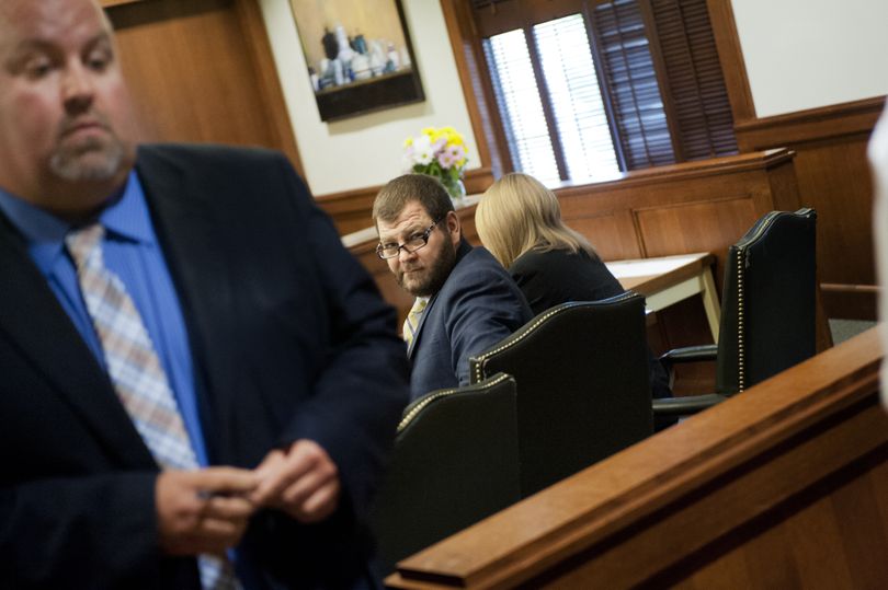 Clay D. Starbuck looks to the back of the courtroom for his children to take the stand with defense attorney Derek Reid, left, during his sentencing hearing Thursday in Spokane County Superior Court. (Tyler Tjomsland)