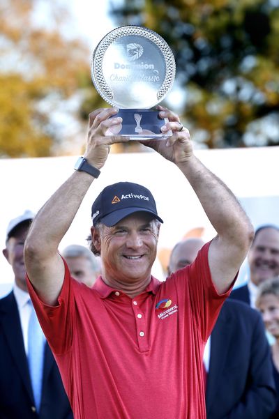 Scott McCarron holds up the trophy after winning the Dominion Charity Classic golf tournament on Sunday. (Alexa Welch Edlund / Associated Press)