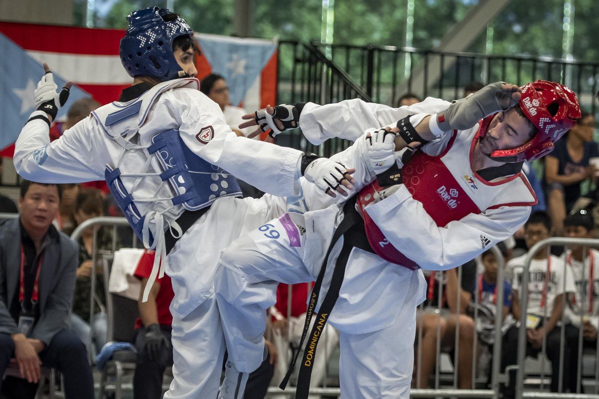 During a Seniors preliminary match, Cesar Rodriguez of Mexico (in blue) and Edward Espinosa of the Dominican Republic (in red) engage each other during the 2018 Pan Am Open International Taekwondo Championships being held in the Spokane Convention Center on Thursday.  Rodriguez won the match. (Colin Mulvany / The Spokesman-Review)