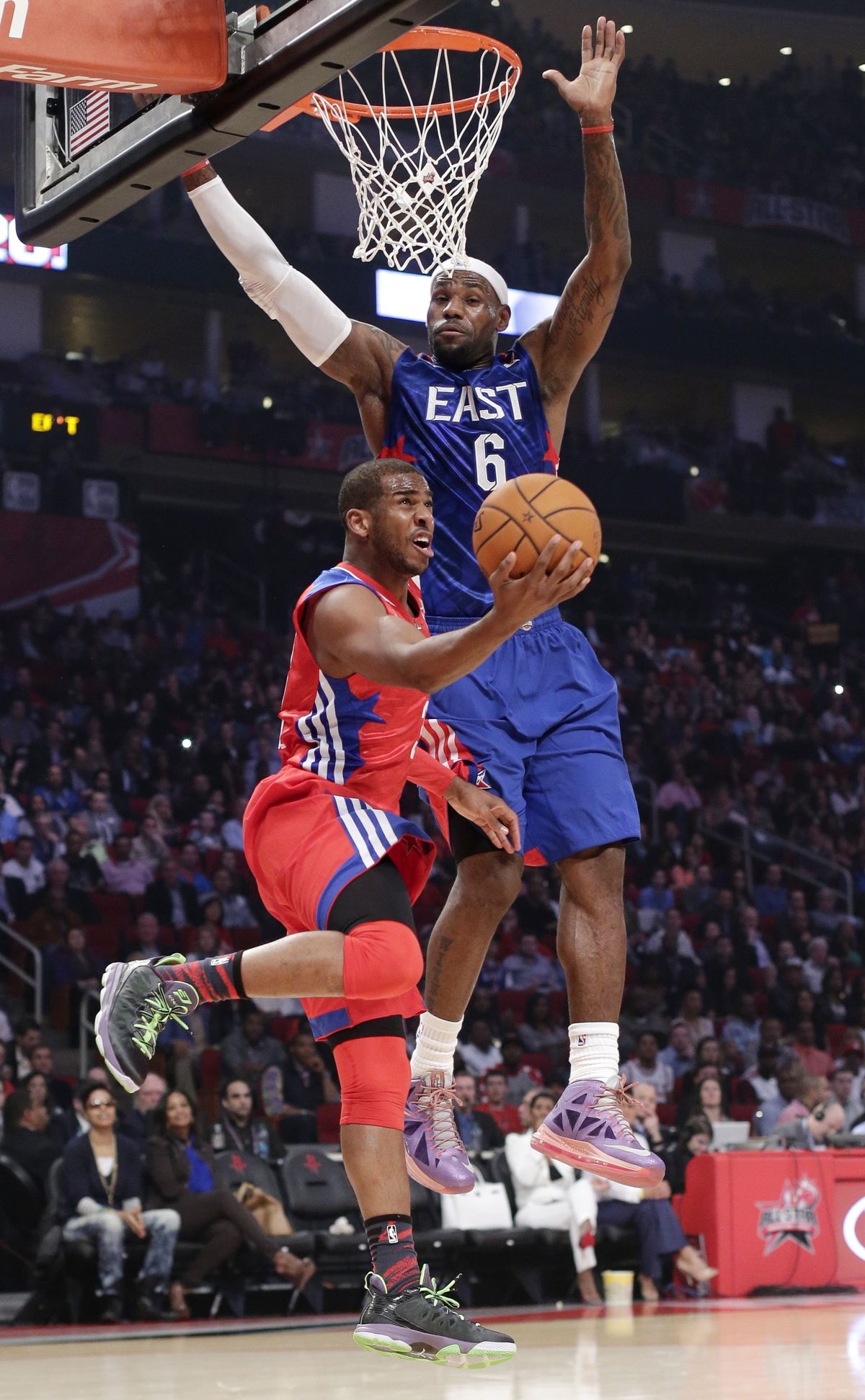 All-Star MVP Chris Paul of the West looks to score against the East’s LeBron James on Sunday. (Associated Press)
