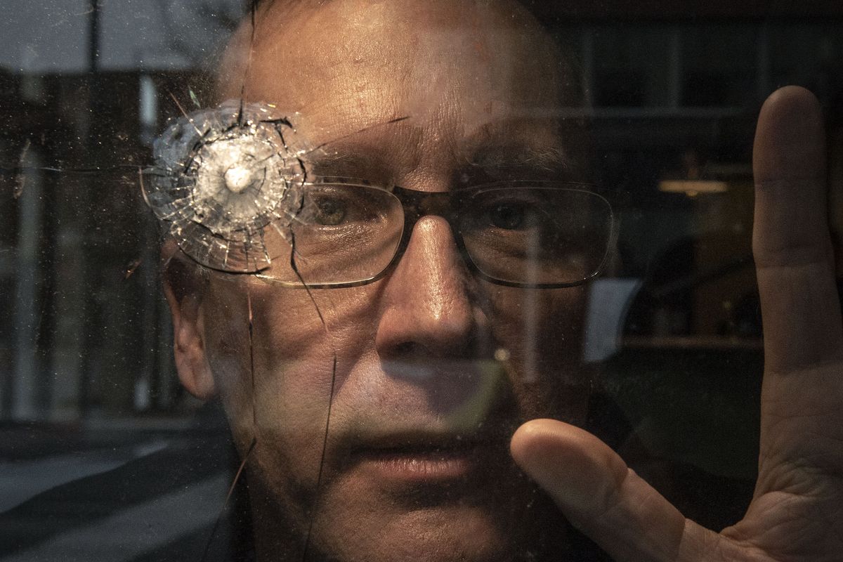 Sean Owens, owner of Common Language Brewing Co., poses next to his vandalized window Friday in the Chronicle Building in downtown Spokane. Multiple windows in the downtown area have recently been damaged by vandals.  (Colin Mulvany/THE SPOKESMAN-REVIEW)