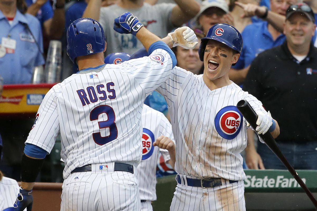 Chicago Cubs’ Chris Coghlan, right, celebrates with David Ross after Ross’ home run during the sixth inning against the Seattle Mariners on Friday in Chicago. (Charles Rex Arbogast / Associated Press)