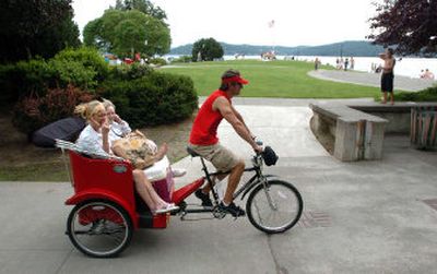 
Driver Matt Tosi, right, takes the passengers in his pedicab, Darla Sutton, left, Tabitha Sutton, 6, in the middle, and Darla's mother Carolyn Hickok, on a ride through the park. 
 (Jesse Tinsley / The Spokesman-Review)