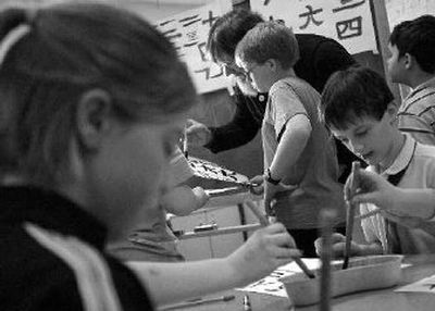
Odyssey program teacher Mike Cantlon, center, works with his students at the Libby Center as they learn the ancient art of Japanese paintbrush calligraphy. 
 (BRIAN PLONKA photos / The Spokesman-Review)