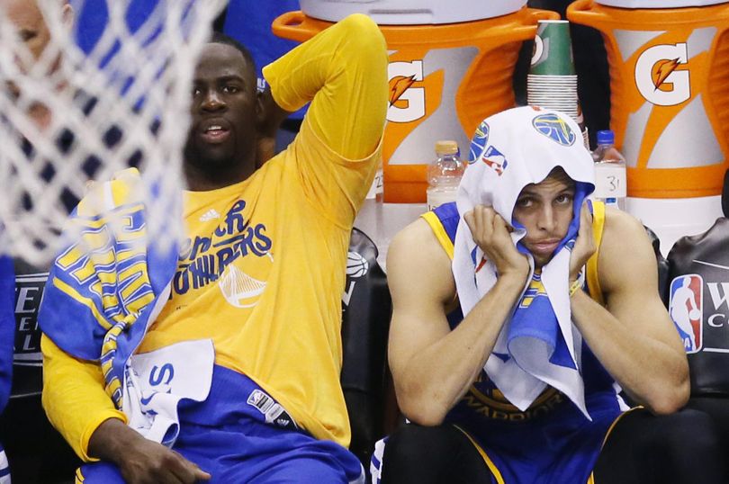 Golden State Warriors players Draymond Green, left and Stephen Curry watch action against the Oklahoma City Thunder during the second half in Game 3 of the NBA basketball Western Conference finals in Oklahoma City, Sunday, May 22, 2016. Oklahoma City won 133-105. (Sue Ogrocki / Associated Press)