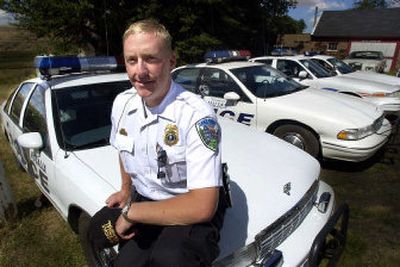 
John Goyke sits on the fender of his Rosalia police car with cruisers for the other towns where he works parked in a line at his home. 
 (Christopher Anderson/ / The Spokesman-Review)