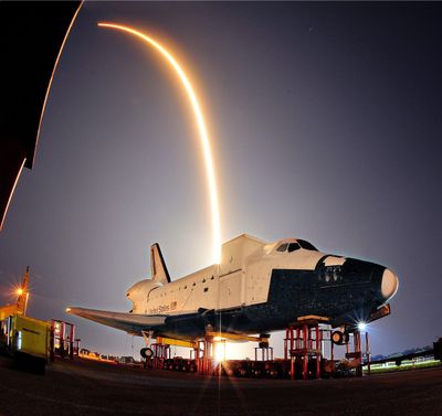 The SpaceX launch of its Falcon 9 rocket and a unmanned Dragon capsule lights up the sky during liftoff from a Cape Canaveral launch pad early Tuesday as it streaks over a model of NASA’s space shuttle at the Kennedy Space Center, heading for a rendezvous with the International Space Station. (Associated Press)