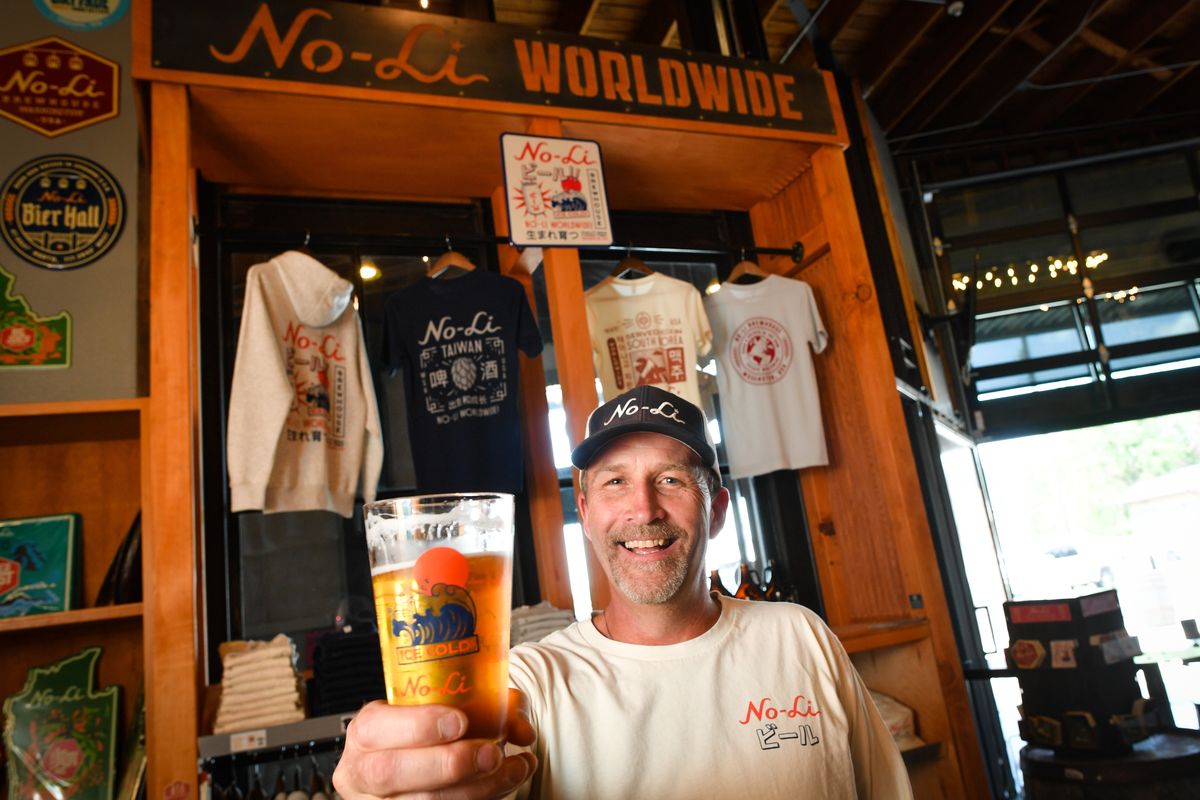 No-Li Owner John Bryant poses Tuesday in front of brewery merchandise reflecting their expansion and accolades overseas. (Tyler Tjomsland/The Spokesman-Review)