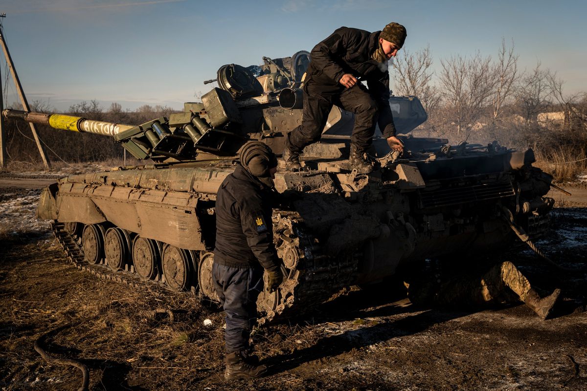 Ukrainian service members work to repair an armored vehicle near the front line town of Kreminna, Ukraine, on Tuesday.  (New York Times)