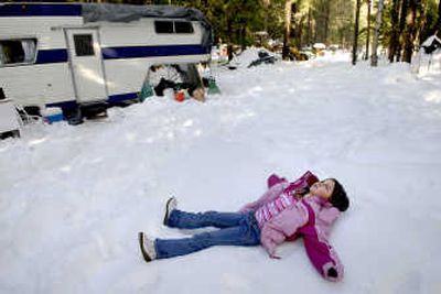 
Jacenta Bonagofski, 6, makes a snow angel earlier this month in front of her family's home off Rapid Lightning Road. Jacenta, who attended school in Clark Fork briefly while her parents tried unsuccessfully to run a restaurant, will now have to be home-schooled. 
 (Photos by Kathy Plonka / The Spokesman-Review)