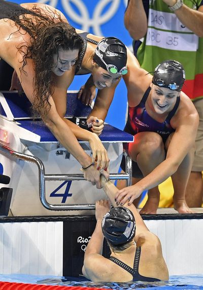USA’s Katie Ledecky, bottom shakes hand with her teammates, from left to right, Allison Schmitt, Maya DiRado and Leah Smith after winning the 4x200-meter freestyle relay final in Rio de Janeiro, Brazil. (Martin Meissner / Associated Press)