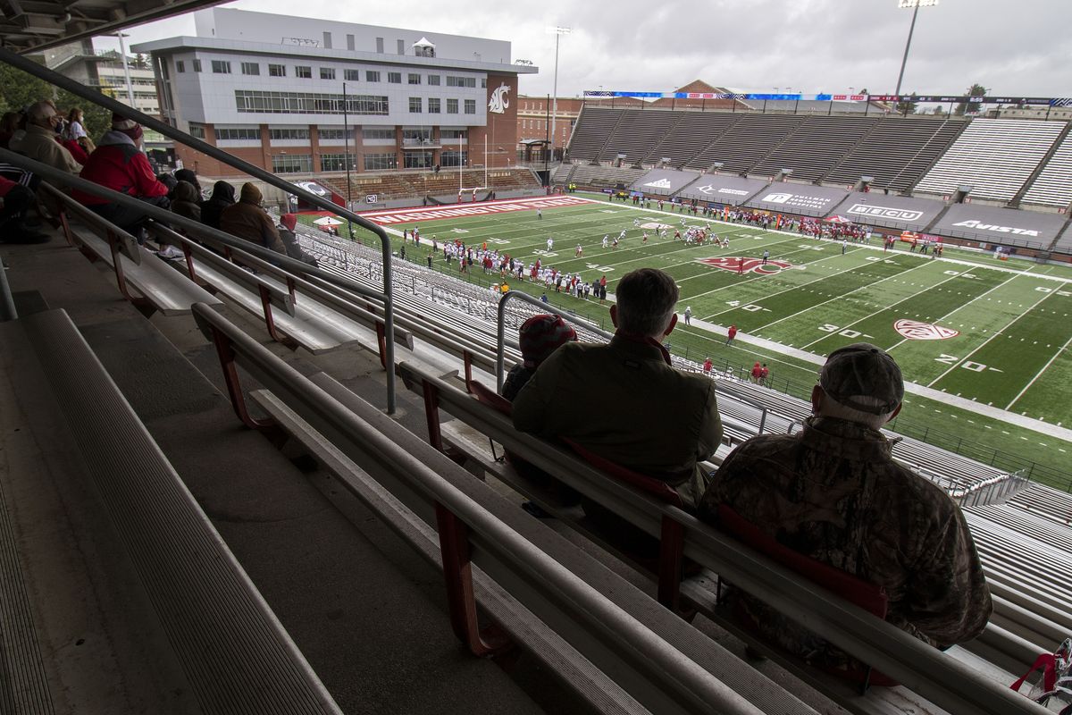 Fans keep dry under an overhang while watching the annual Crimson and Gray scrimmage on Saturday, April 24, 2021, at Martin Stadium in Pullman, Wash. Only family members of the players were allowed to attend the scrimmage because of restrictions related to the COVID-19 Pandemic.  (Geoff Crimmins/For the Spokesman)
