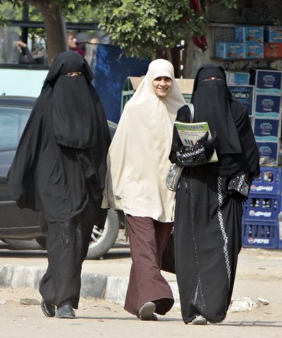 Egyptian students wearing the face-covering veil, known as the niqab, walk with another wearing less severe clothing in Cairo, Egypt, on Thursday.  (Associated Press / The Spokesman-Review)