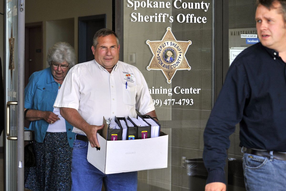 Alan Creach packs out a box of reports from the Spokane County Sheriff’s Office Training Center in Spokane Valley on Wednesday after a meeting with Sheriff Ozzie Knezovich about the investigation into the fatal shooting of his father, Scott Creach. Also in the two-hour meeting were Creach’s brother, Ernie, right, and their mother, Imogene. (Dan Pelle)