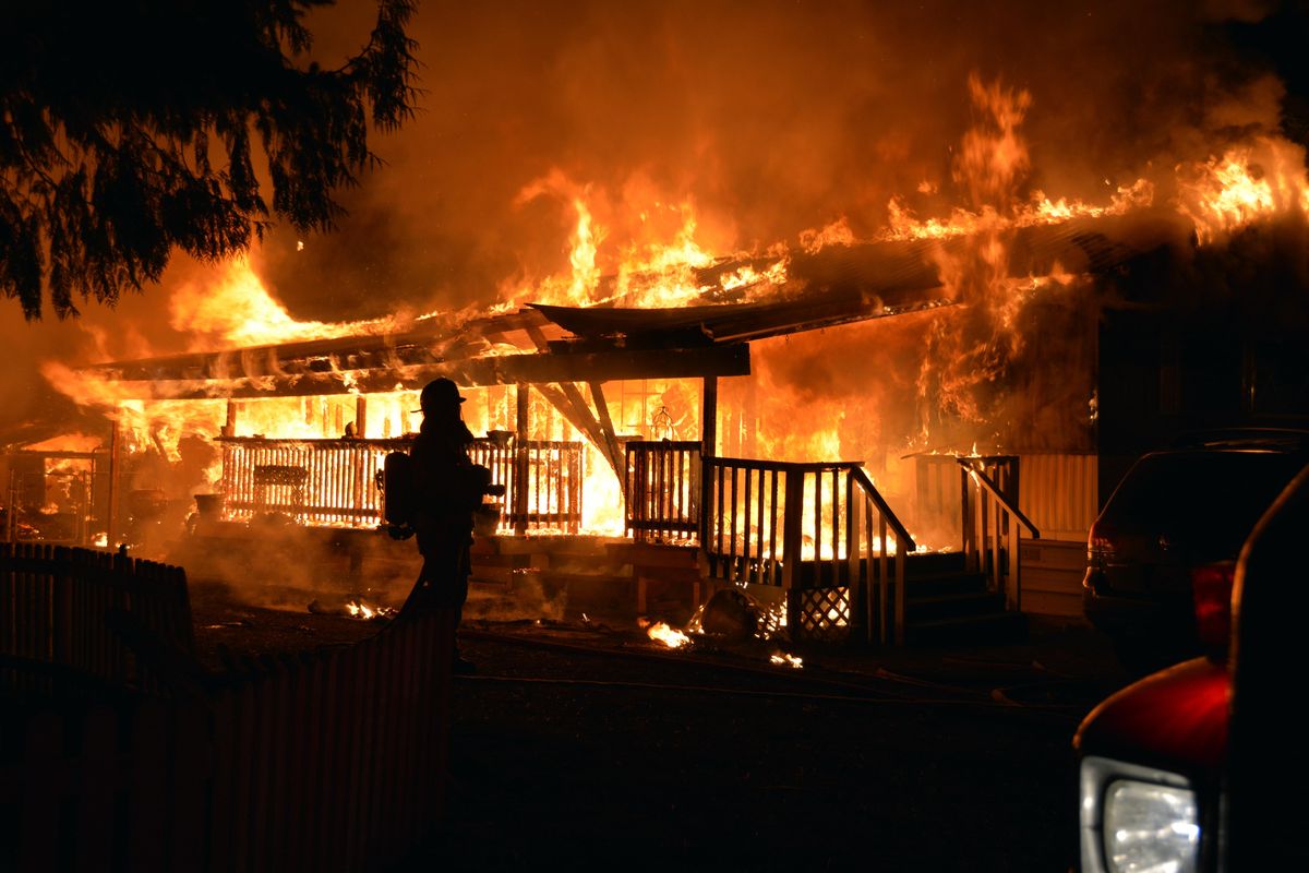 A home on Gwenelen Road in the Morgan Park neighborhood of Loon Lake is destroyed by fire on Sunday night. (Joe Palmquist / The Spokesman-Review)