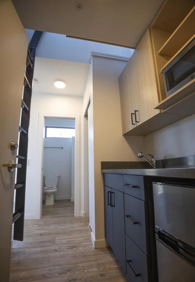 The entrance to an apartment in The Kärsti apartments in Seattle. The ladder at left leads to a sleeping loft. To the left, out of frame is a living room area.  (Ellen M. Banner/Seattle Times)