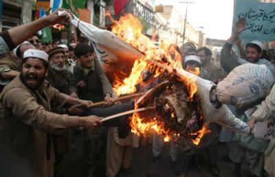 
Pakistani protesters burn an effigy of  President Bush at a rally in Peshawar on Friday to condemn last week's missile strikes in the Pakistani tribal territory of Bajour that  killed 13 civilians and possibly several top al-Qaida operatives. 
 (Associated Press / The Spokesman-Review)