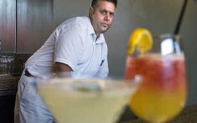 
Garth Hicks takes a final look at the drinks he has made using herbs – a Wild Sage and a Lavender Sunset – at the Wild Sage Bistro at Second Avenue and Lincoln Street in downtown Spokane. 
 (CHRISTOPHER ANDERSON / The Spokesman-Review)