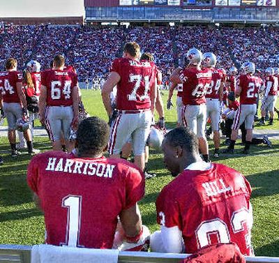 
 Injured receiver Jason Hill sits with Jerome Harrison on the sideline. Several key WSU players such as Hill missed the game. 
 (Christopher Anderson/ / The Spokesman-Review)