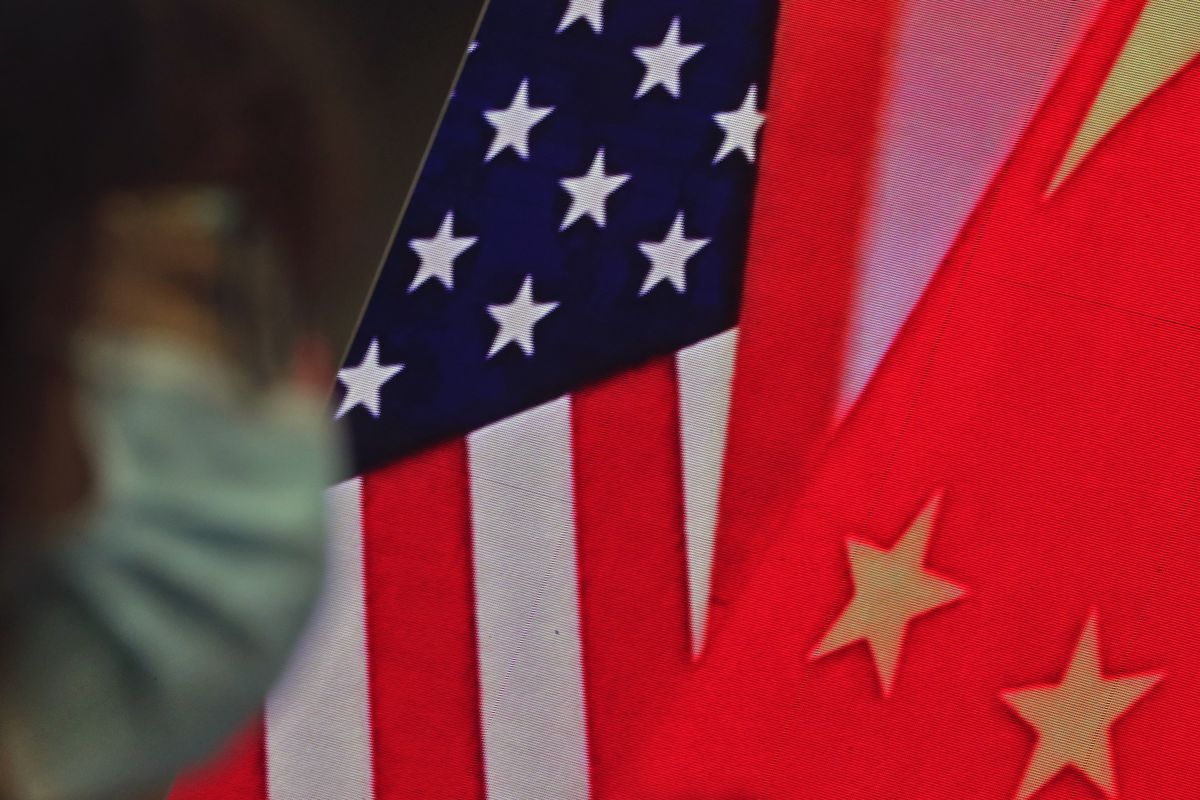 In this Feb. 22, 2021, file photo, a woman wearing a face mask sits near a screen showing China and U.S. flags as she listens to a speech by Chinese Foreign Minister Wang Yi at the Lanting Forum on bringing China-U.S. relations back to the right track, at the Ministry of Foreign Affairs office in Beijing. In a relationship as fraught as America's and China's, just an agreement that talks were productive was a sign of progress. Nine months into Joe Biden's presidency, the two sides finally appear to be trying to ease tensions that date from the Trump administration — though U.S. complaints about Chinese policies on trade, Taiwan and other issues are little diminished.  (Andy Wong)