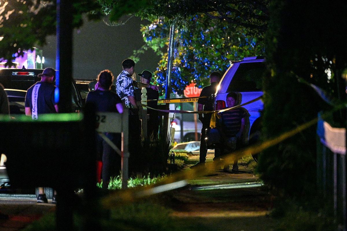 People stand near the crime scene in the 1000 block of Paddington Place in Annapolis Sunday night after six people were shot in an "interpersonal dispute," killing three men and hospitalizing three others.  (Tribune News Service)