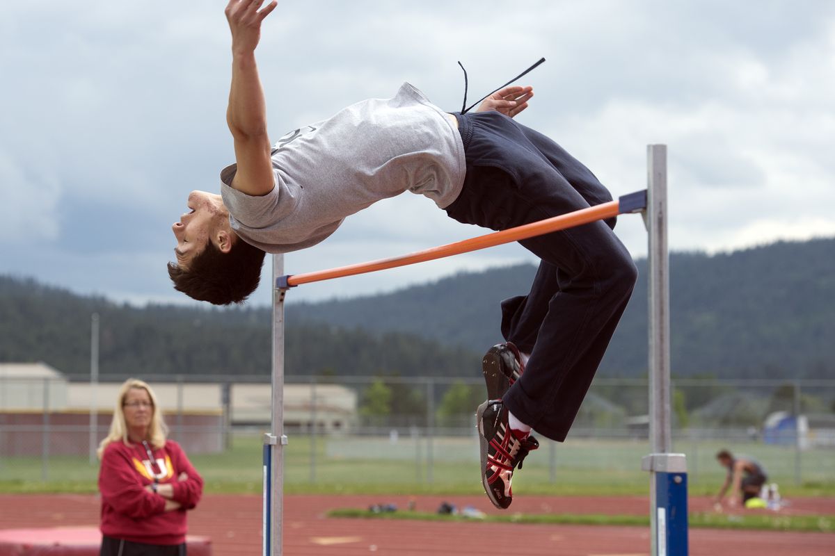 University High School senior Eddie Gonzalez attempts a 6-foot, 5-inch height in the high jump during track and field practice under the watchful eye of his coach, Liz Wardsworth, on Thursday in Spokane Valley. (PHOTOS BY DAN PELLE)