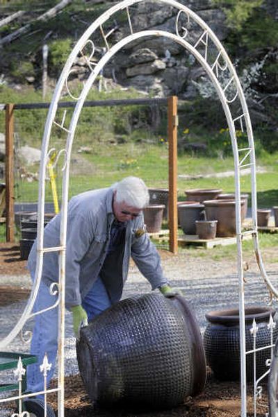 
Ed Peck rolls out a 35-gallon garden container for a customer at the Secret Garden in Spokane Valley. 
 (Dan Pelle / The Spokesman-Review)