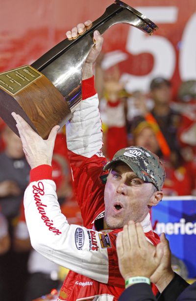 Kevin Harvick raises the trophy after winning the Bank of America 500 auto race. (Associated Press)