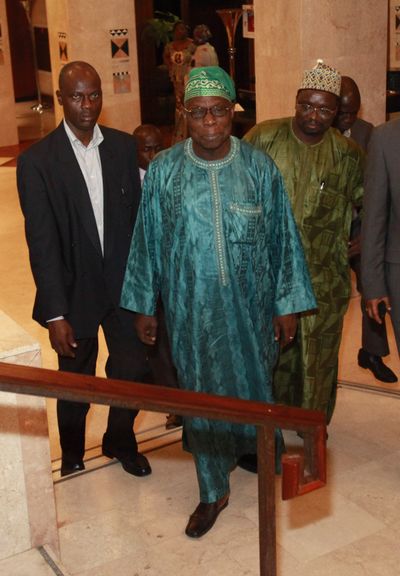 Former Nigerian President Olusegun Obasanjo, center, heads to a meeting with Laurent Gbagbo on Saturday.  (Associated Press)