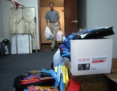 
Spokane Valley Community Center CEO Ken Briggs brings bags of donated school supplies to the room in the Spokane Valley Community Center where they will be counted. Briggs is the new director of the center and the food bank. 
 (Liz Kishimoto / The Spokesman-Review)