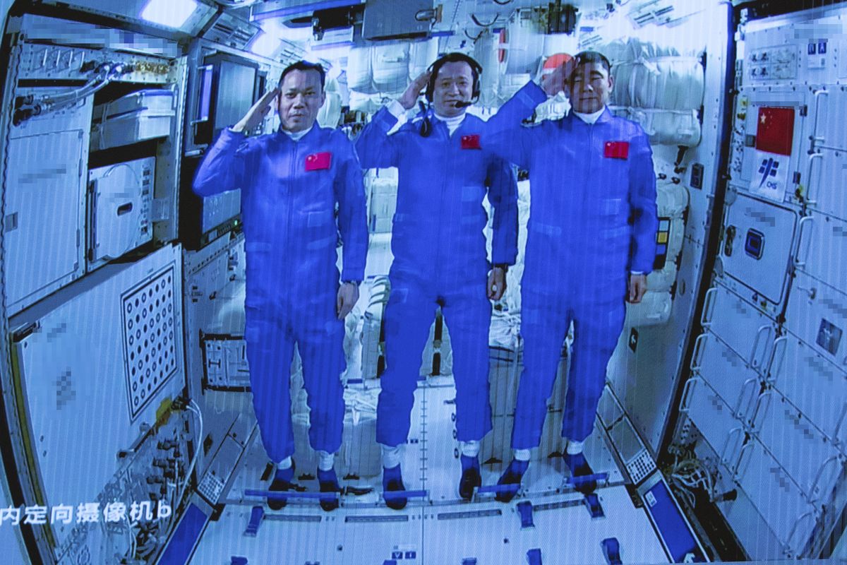 In this photo released by Xinhua News Agency, Chinese astronauts salute after successfully entering the Tianhe space station module as they are displayed on a big screen at the Beijing Aerospace Control Center in Beijing, on Thursday, June 17, 2021. China has launched the first three-man crew to its new space station in its the ambitious programs first crewed mission in five years  (Jin Liwang)