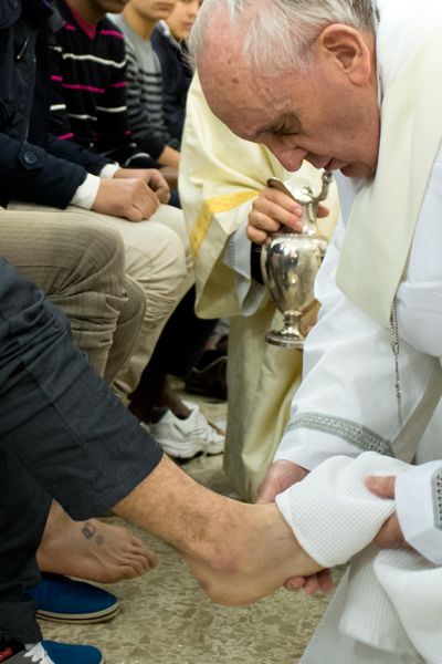 In this photo provided by the Vatican newspaper L'Osservatore Romano, Pope Francis washes the foot of an inmate at the juvenile detention center of Casal del Marmo, Rome, Thursday, March 28, 2013. Francis washed the feet of a dozen inmates at a juvenile detention center in a Holy Thursday ritual that he celebrated for years as archbishop and is continuing now that he is pope. Two of the 12 were young women, an unusual choice given that the rite re-enacts Jesus' washing of the feet of his male disciples. The Mass was held in the Casal del Marmo facility in Rome, where 46 young men and women currently are detained. Many of them are Gypsies or North African migrants, and the Vatican said the 12 selected for the rite weren't necessarily Catholic. (L'osservatore Romano)