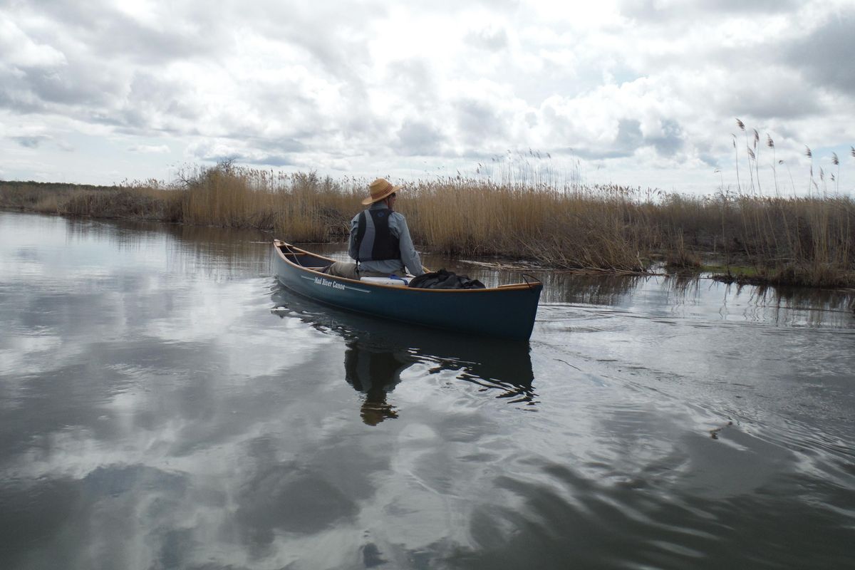 Alone with his thoughts, a solitary paddler explores the intersection of sky and water along the Winchester Wasteway. (William Brock / Courtesy)