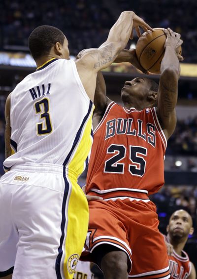Indiana guard George Hill, left, blocks the shot of Chicago Bulls guard Marquis Teague during the Pacers’ division-tying win. (Associated Press)