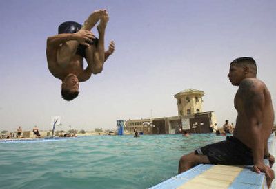 
U.S. Army Pfc. Stephen Thomas of Gainsville, Florida jumps into the swimming pool at Camp Victory in Baghdad on Tuesday.
 (Associated Press / The Spokesman-Review)