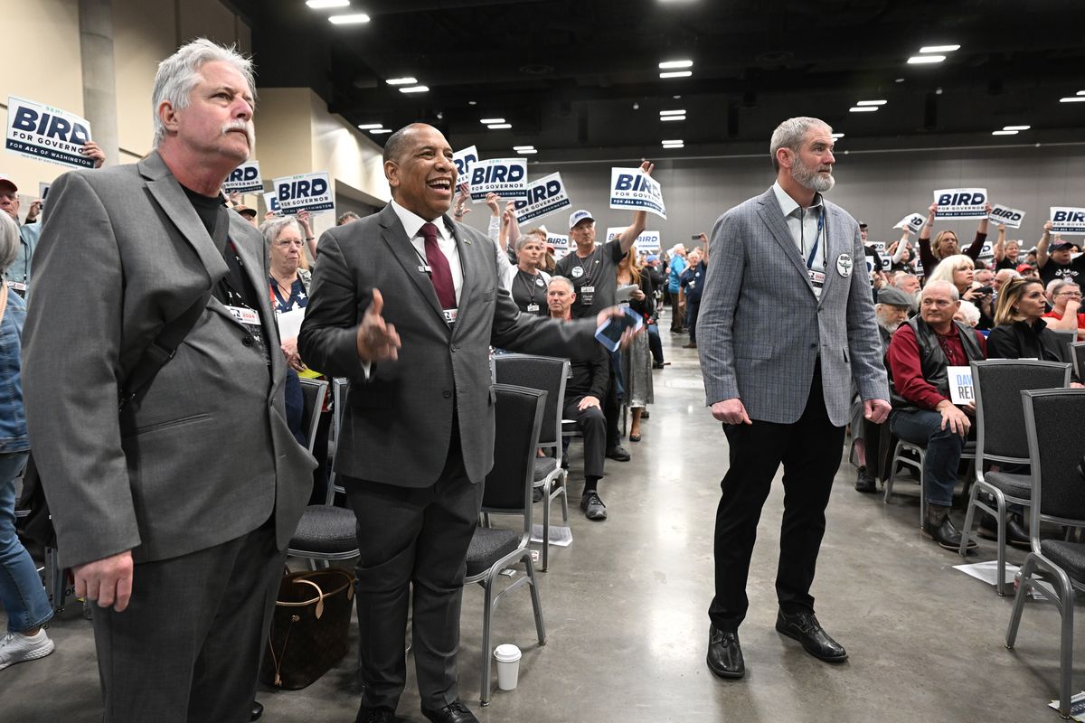 Washington gubernatorial candidate Semi Bird, second from left, stands up and watches as hundreds of delegates raise his signs Friday at the Spokane Convention Center.  (Jesse Tinsley/THE SPOKESMAN-REVIEW)