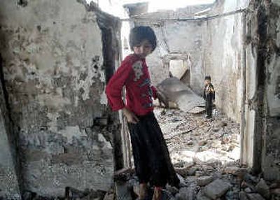 
Children search amid the charred ruins of a police station burned during rioting in the Uzbek border town of Korasuv, about 290 miles east of the Uzbek capital Tashkent. 
 (Associated Press / The Spokesman-Review)