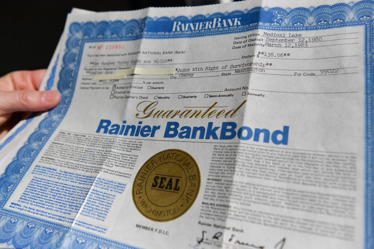 Heather Carlon holds the bond on Wednesday that her father purchased in 1980 from Rainier Bank. The bond was purchased for $138.56 and carried an interest rate of 11.25%.  (Tyler Tjomsland/THE SPOKESMAN-REVIEW)