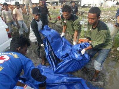 
 Indonesian Red Cross workers remove a newly found tsunami victim at Kampung Mulia village in Banda Aceh earlier this month. 
 (Associated Press / The Spokesman-Review)