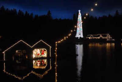 
Santa and Mrs. Claus appear inside a floating boathouse at Casco Bay on Lake Coeur d'Alene Tuesday evening  as boats from Coeur d'Alene Cruises pass by. 
 (Jesse Tinsley / The Spokesman-Review)