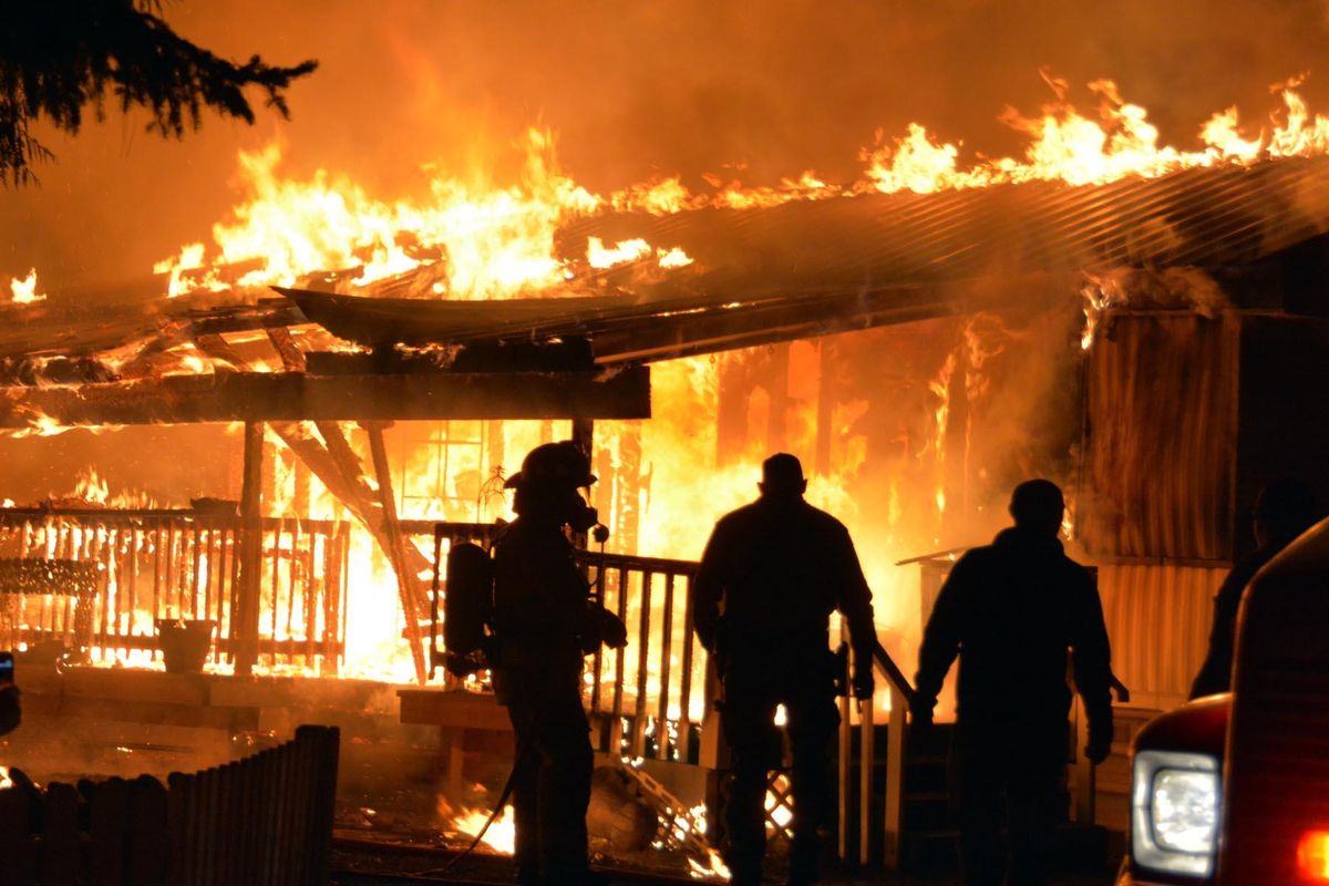 Stevens County firemen watch as a home on Gwenelen Road in the Morgan Park neighborhood of Loon Lake is destroyed by fire  Sunday night. (Joe Palmquist / The Spokesman-Review)